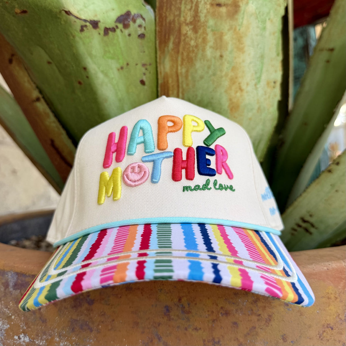 Natural-colored cap with multicolor Happy Mother embroidery, a pink smiley face and rainbow-striped brim with aqua trim — Blair's Western Wear Marble Falls TX