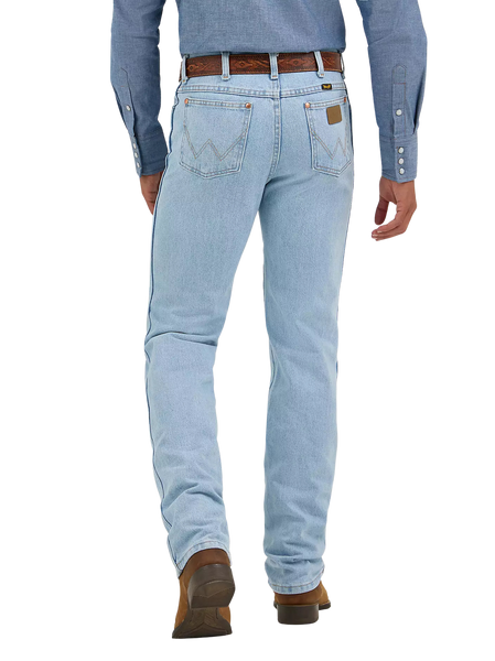 Men's bleach wash slim fit cowboy cut jean back view with iconic W-stitch pockets and Wrangler leather patch, styled with western shirt and boots — Blair's Western Wear Marble Falls TX