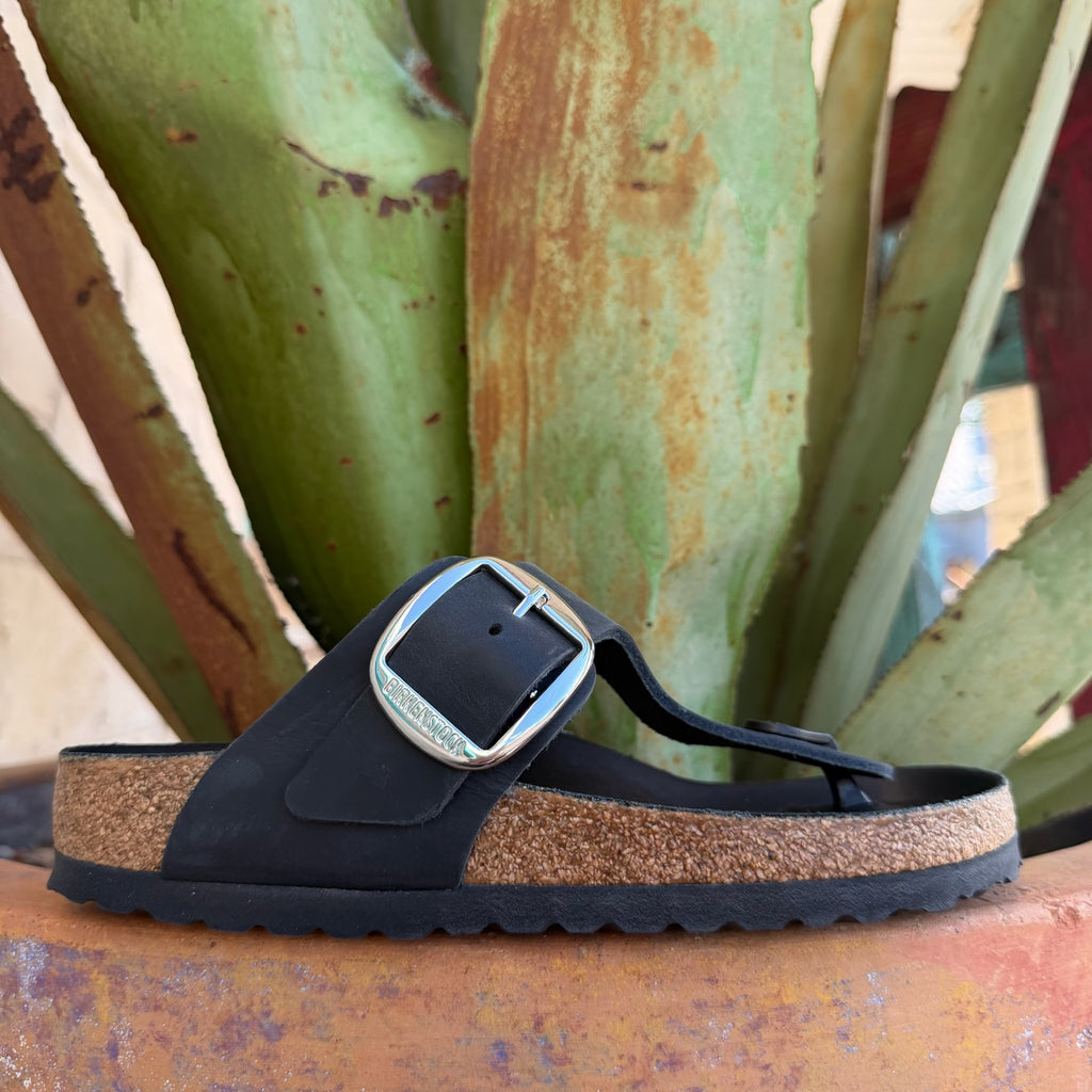 Women's black Birkenstock Gizeh Big Buckle thong sandal showing contoured cork footbed, toe post, and oversized silver buckle detail, top-down view — Blair's Western Wear Marble Falls TX