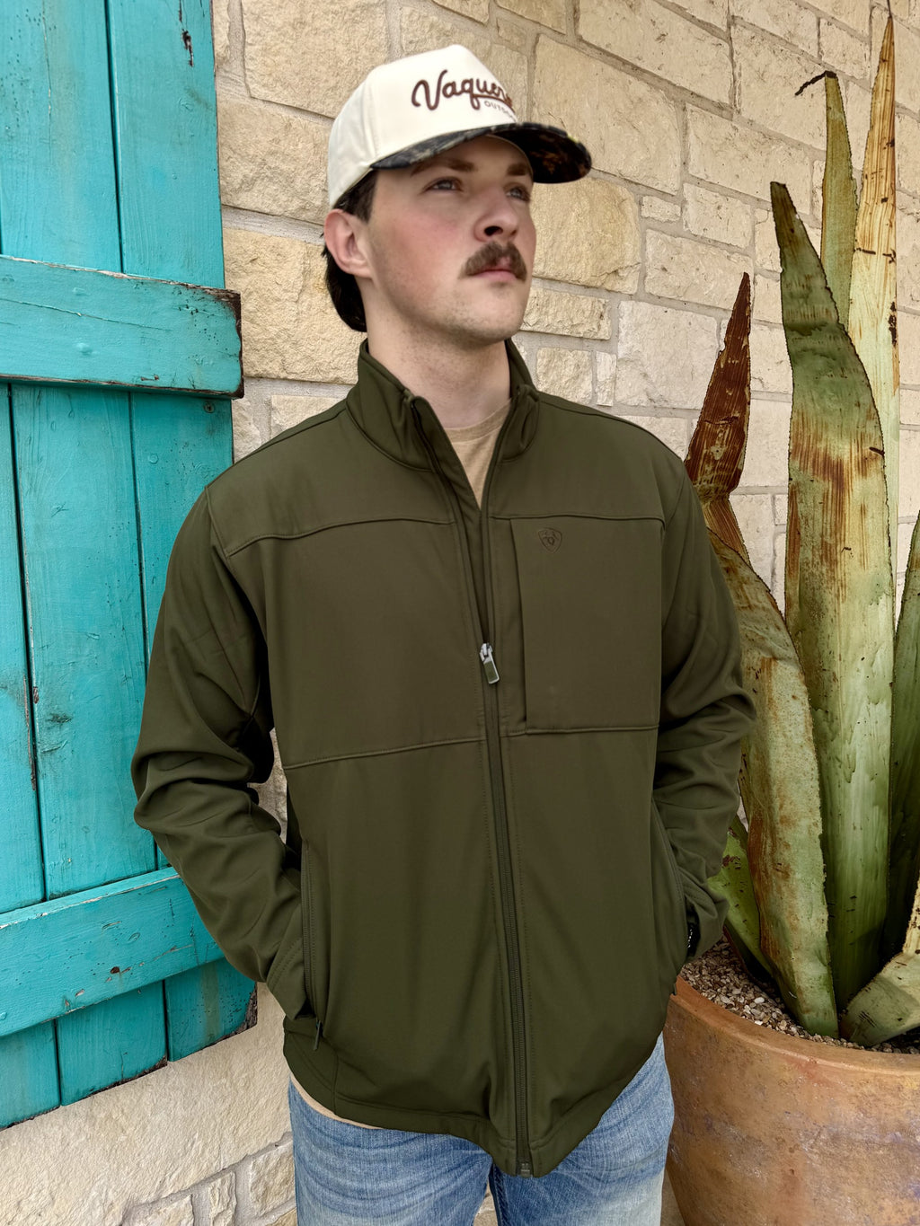Men's olive softshell jacket with stand collar, full zip-front closure, horizontal chest seams, side pockets, long sleeves, and tonal embroidered chest logo — Blair's Western Wear Marble Falls TX