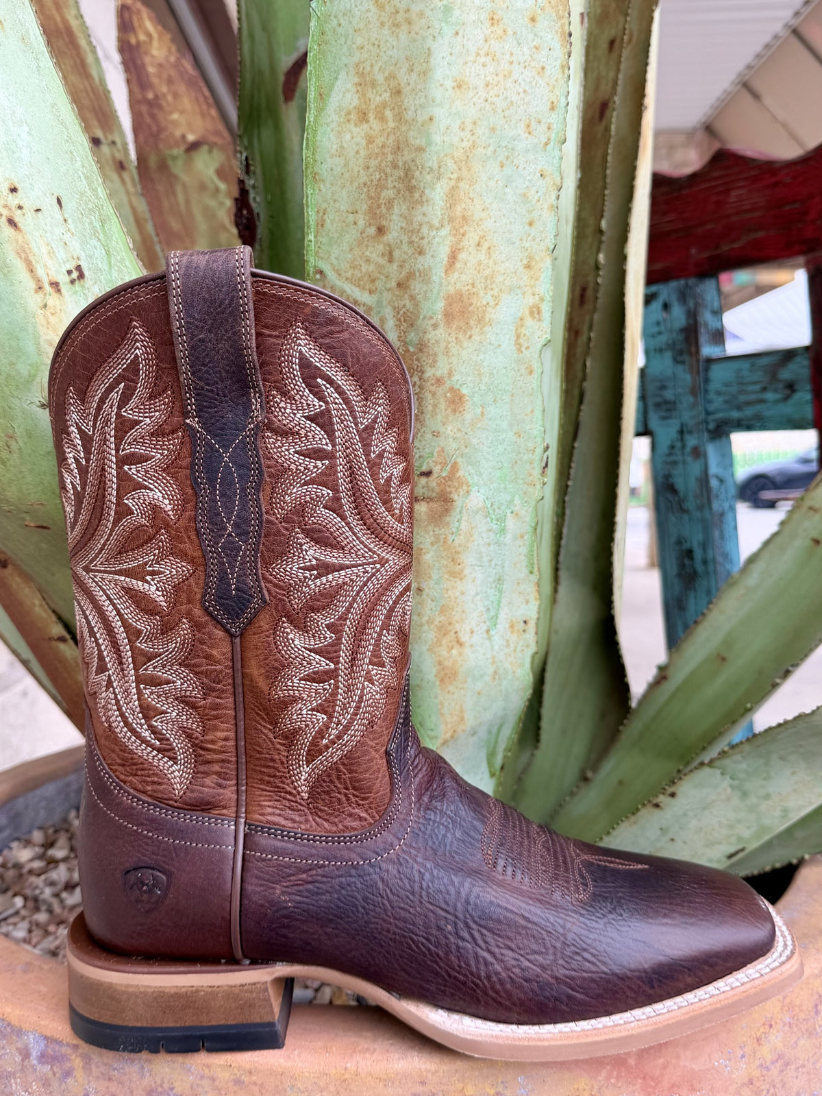 Chocolate-brown boot heel and side seam beneath a tan shaft with contrasting embroidery — Blair's Western Wear Marble Falls TX
