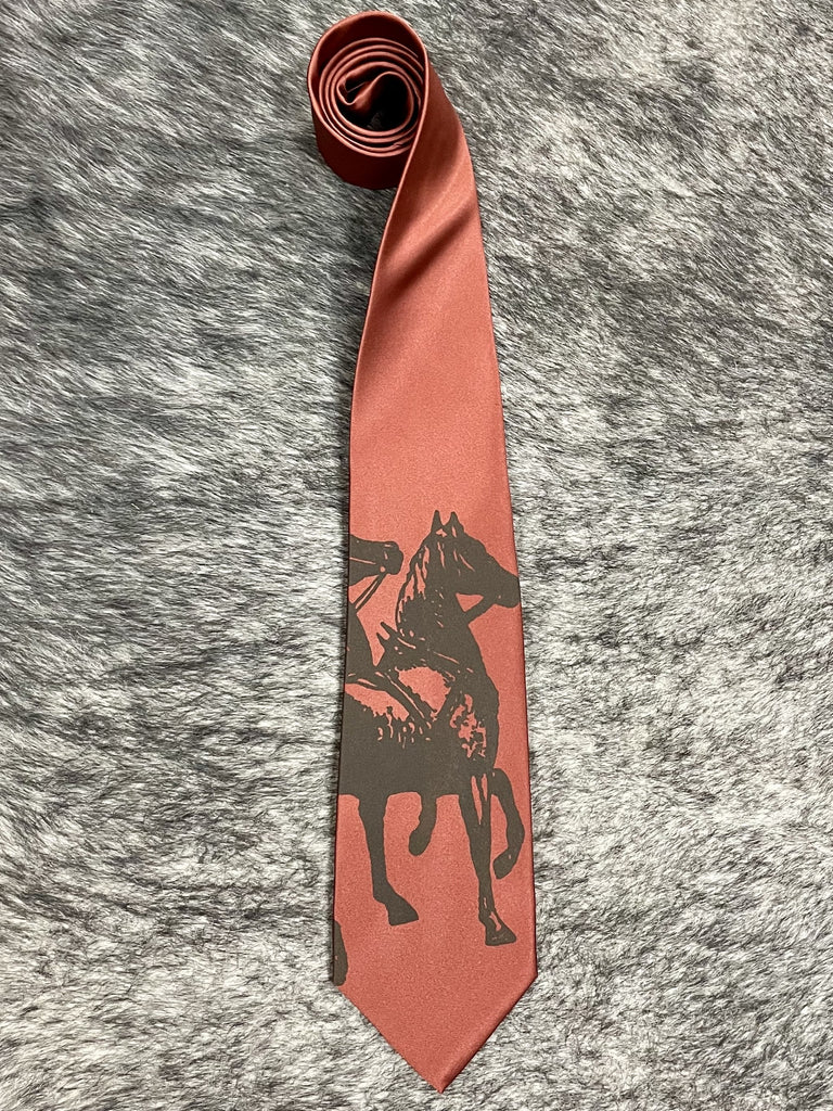 Men's cinnamon terracotta satin necktie with tonal dark brown rearing horse and rider silhouette print, smooth finish, standard width pointed tip — Blair's Western Wear Marble Falls TX
