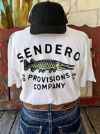 Men's white Sendero Provisions Co. Alligator Gar short sleeve tee with green black alligator gar fish chest logo and Sendero Provisions Co. text, front view styled with jeans and tooled leather belt — Blair's Western Wear Marble Falls TX
