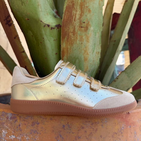Women's metallic gold low-top sneaker with beige suede panels, velcro closure, and chunky gum sole — Blair's Western Wear Marble Falls TX
