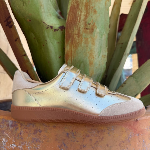 Women's metallic gold low-top sneaker with beige suede panels, velcro closure, and chunky gum sole — Blair's Western Wear Marble Falls TX
