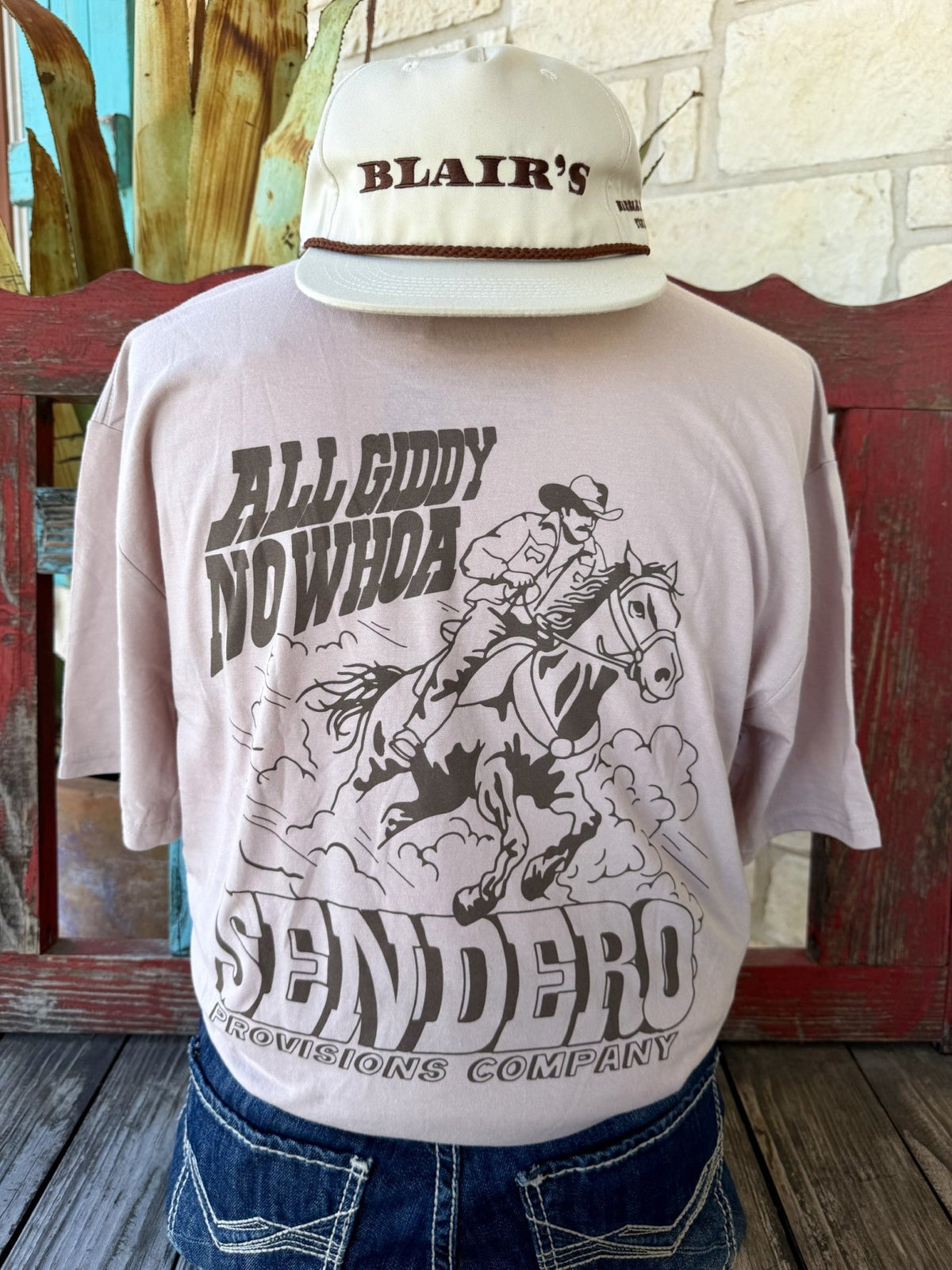 Men's tan Sendero Provisions Co. All Giddy No Whoa short sleeve tee with chocolate cowboy on horseback back graphic and Sendero Provisions Company banner, back view — Blair's Western Wear Marble Falls TX