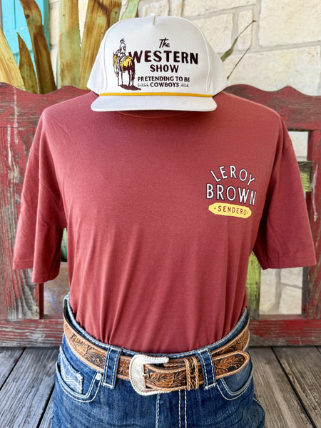 Men's brick red Sendero Provisions Co. Leroy Brown short sleeve tee with white yellow Leroy Brown Sendero chest badge, front view styled with jeans and tooled leather belt — Blair's Western Wear Marble Falls TX