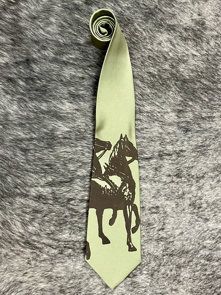 Men's sage green satin necktie with tonal dark brown rearing horse and rider silhouette print, smooth finish, standard width pointed tip — Blair's Western Wear Marble Falls TX