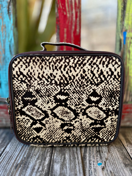American Darling Makeup Case Hide in Black/Natural, crafted with genuine hair-on hide for a bold one-of-a-kind look, with 10.5" x 7" x 3.5" structured design and full-grain leather back - ADBGA229. Available at Blair's Western Wear, Marble Falls, TX.