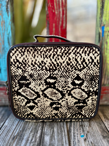 American Darling Makeup Case Hide in Black/Natural, crafted with genuine hair-on hide for a bold one-of-a-kind look, with 10.5" x 7" x 3.5" structured design and full-grain leather back - ADBGA229. Available at Blair's Western Wear, Marble Falls, TX.
