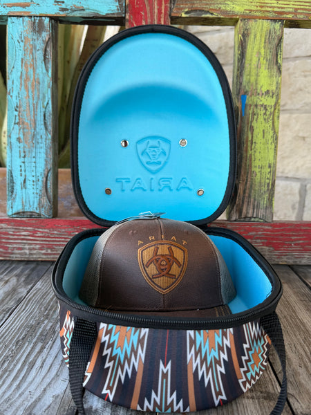 Keep your favorite caps safe and travel-ready with the Ariat Cap Carrier A3099897. Designed in a bold brown, black, and turquoise Aztec pattern, this sturdy case holds 4–6 caps without losing their shape. Perfect for rodeos, road trips, or everyday storage—stylish, practical, and built the Ariat way. Available at BLAIR'S Western Wear located in Marble Falls TX.