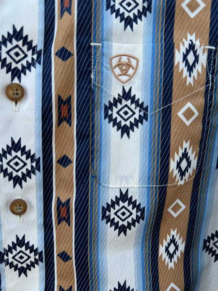 Close up of Boy's Long Sleeve Ariat Aztec Shirt - 10062394. This shirt features a blue, navy, tan, brown and white aztec pattern and it has a pocket on the left side of the chest. Available at Blair's Western Wear located in Marble Falls. TX