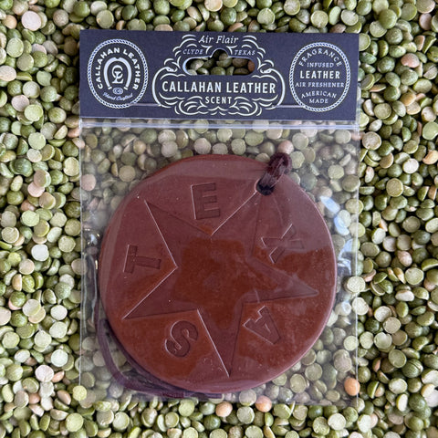 Callahan Leather Air Freshener Texas Star Flag in Brown, crafted from full-grain vegetable-tanned leather, infused with signature leather scent, featuring a round medallion design with embossed Texas star and "TEXAS" lettering, includes hanging cord - AFRVTFBRWLTH. Available at Blair's Western Wear, Marble Falls, TX.