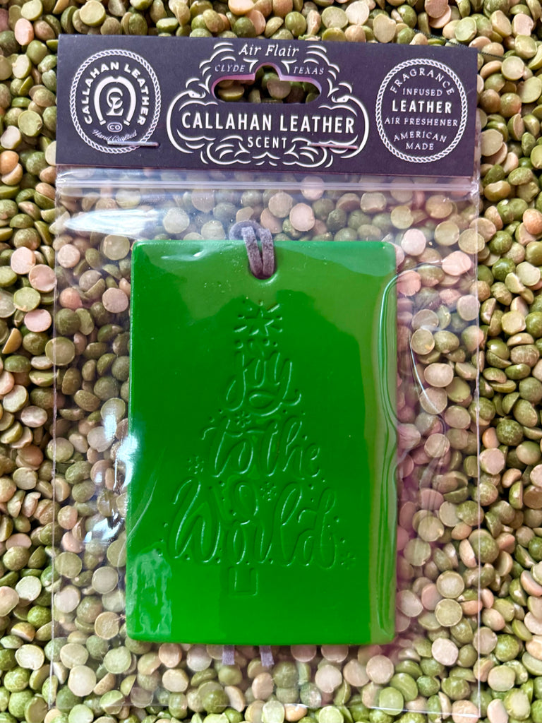 Callahan Leather air freshener rectangle in green, featuring an embossed “Joy to the World” design, with long-lasting fragrance-infused leather and a durable leather cord for hanging - AFRDJTTGRNCCRCT. Available at Blair's Western Wear, Marble Falls, TX.