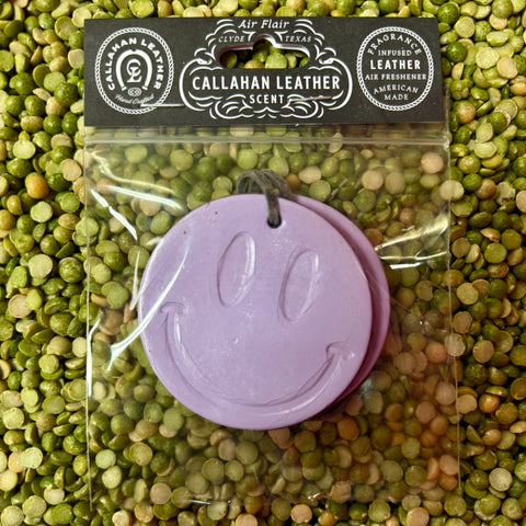 Callahan Leather air freshener lilac smiley, infused with long-lasting leather scent, with a durable hanging cord for easy placement – AFDBLSMILELLCLTH. Available at Blair's Western Wear, Marble Falls, TX.