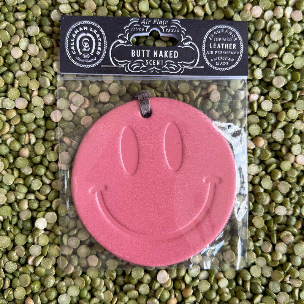 Callahan Leather Air Freshener Smiley Face in Pink, crafted from full-grain leather, infused with a fruity “Butt Naked” scent, with a bold smiley design and leather hanging strap – AFRSMILPNKBN. Available at Blair's Western Wear, Marble Falls, TX.