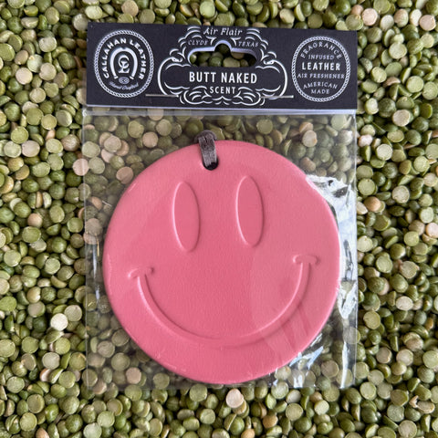 Callahan Leather Air Freshener Smiley Face in Pink, crafted from full-grain leather, infused with a fruity “Butt Naked” scent, with a bold smiley design and leather hanging strap – AFRSMILPNKBN. Available at Blair's Western Wear, Marble Falls, TX.