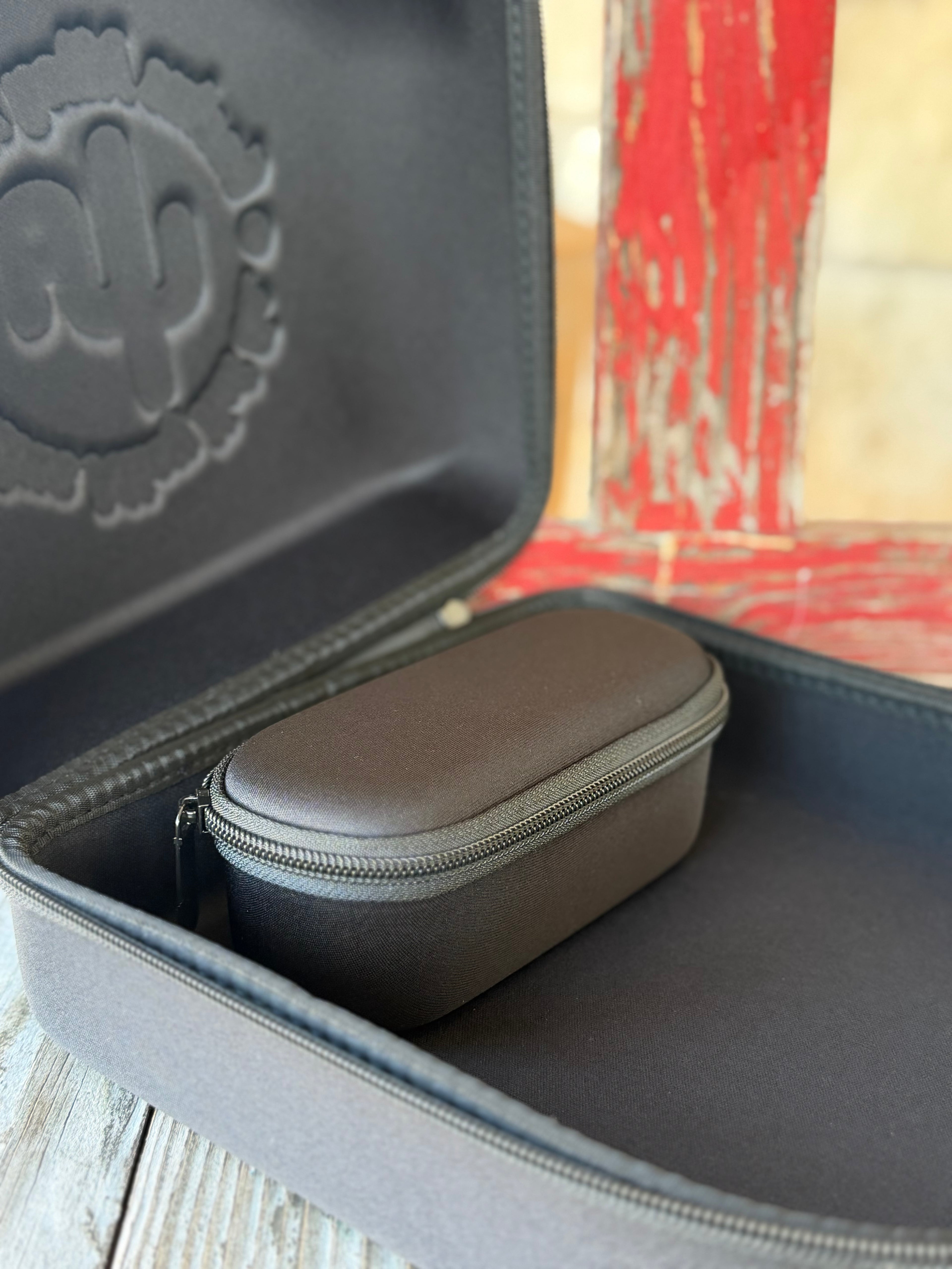 The Cactus Ally Hat Company Cap Carrier keeps your favorite caps protected and organized on the go. Designed in sleek black, it holds 4–5 caps securely and includes a built-in sunglasses case for added convenience. Carry it your way with both handheld and shoulder strap options—perfect for travel, rodeos, or everyday use. Available at BLAIR'S Western Wear located in Marble Falls, TX 