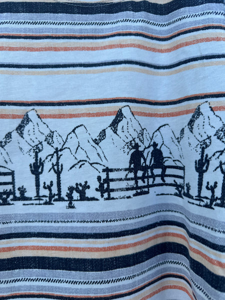 Close up of Girl's Short Sleeve Western Tee - CTK8005003 - This striped and colorful shirt features the cutest puffy sleeves and it has  cute little western graphics of cowboys in a rocky  background setting. Available at Blair's Western Wear located in Marble Falls TX