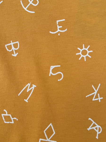 Close up of Girl's Short Sleeve Western Tee - CTK8005002 - This golden colored girl shirt features the cutest puffy sleeves and it was acute little western symbols all throughout. Available at Blair's Western Wear located in Marble Falls TX