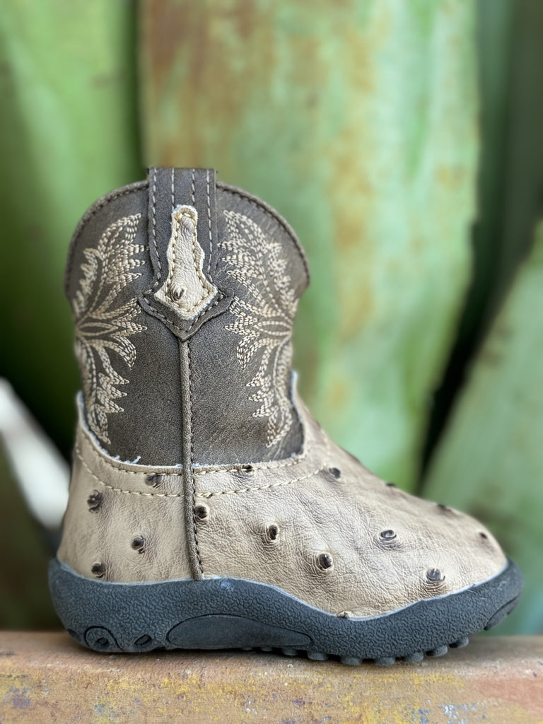Introduce your baby to upscale Western wear with this charming Infant Baby Roper Boot! Made from leather with a stylish tan ostrich texture, this boot offers a luxurious look for tiny feet. Designed for ease and comfort, it features a handy side zipper for quick changes. The durable rubber sole provides excellent traction and flexibility for little explorers on the move.  Infant Roper Boot - 91612243500 - Available at BLAIR'S Western Wear located in Marble Falls TX 