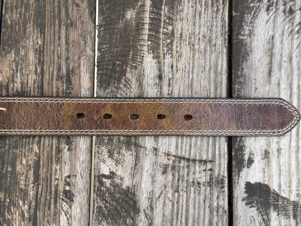 A close-up of a brown leather belt end with 5 belt holes. Available at Blair's Western Wear, Marble Falls, TX