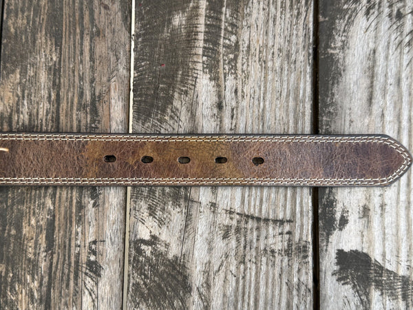 A close-up of a brown leather belt end with 5 belt holes. Available at Blair's Western Wear, Marble Falls, TX