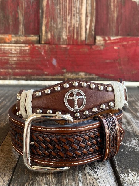 Kid’s Cowboy Chrome Cross Gallop Kids Belt in brown leather, with basketweave tooling and silver-tone domed nailheads plus cross concho detailing and scalloped rawhide braid – 855. Available at Blair's Western Wear, Marble Falls, TX.