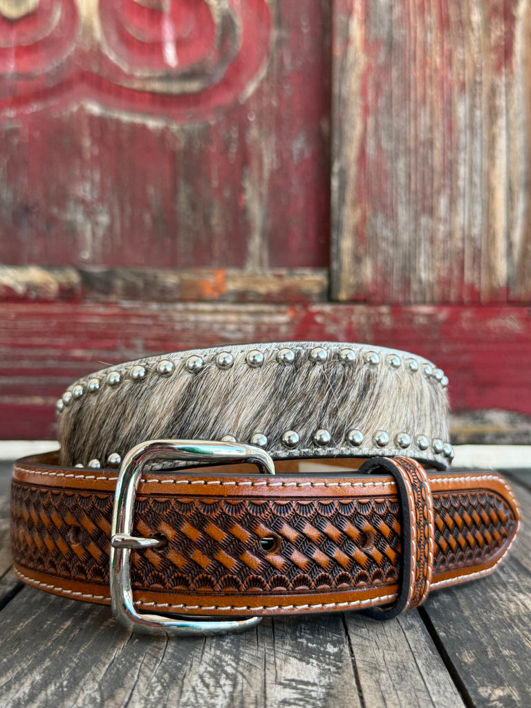 This belt features rich brown full-grain leather with a beautifully detailed basketweave tooling pattern, contrasting white stitching, and a polished silver buckle. The genuine hair-on hide leather accent adds natural texture and character, making each belt one of a kind with its own unique color variations and markings.
Available at Blair's Western Wear located in Marble Falls TX 