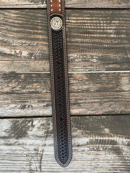 Western belt featuring a dark brown hand-tooled basketweave pattern with contrasting white stitching. The center is accented with distressed brown leather and two rows of antique silver studs for added detail. It also features 2 Praying Cowboy Stud Conchos. Finished with a polished silver roller buckle and matching leather keeper, this belt is built for durable everyday wear.Available at Blair's Western Wear, Marble Falls, TX
