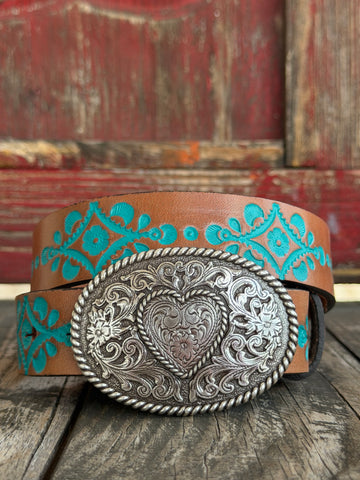 Warm tan leather is painted with a bold turquoise floral vine pattern and paired with a large oval engraved silver buckle featuring a scrollwork heart center — Available at BLAIR'S Western Wear located in Marble Falls TX 
