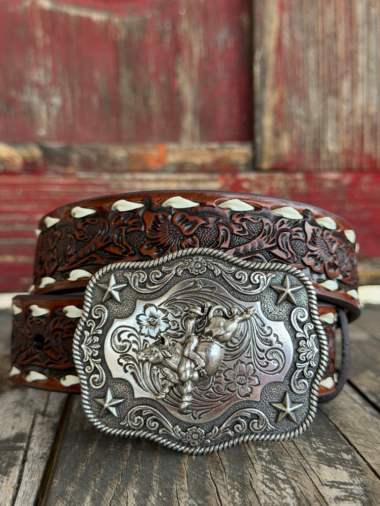 Rich dark brown floral-tooled leather is edged with white whipstitching and paired with a large engraved silver buckle featuring a bucking bronco rider, rope border, and star corners — classic rodeo character in a kid-sized belt - Available at BLAIR'S Western wear located in Marble Falls TX 