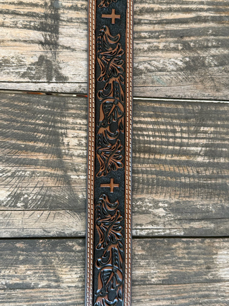 Leather Western belt featuring a hand-tooled floral pattern with a textured black background and a centered cross design. Finished with double white contrast stitching, matching leather keeper, and a polished silver roller buckle. Built for everyday wear with durable leather construction and classic Western craftsmanship.

Available at Blairs' Western Wear, located in Marble Falls.