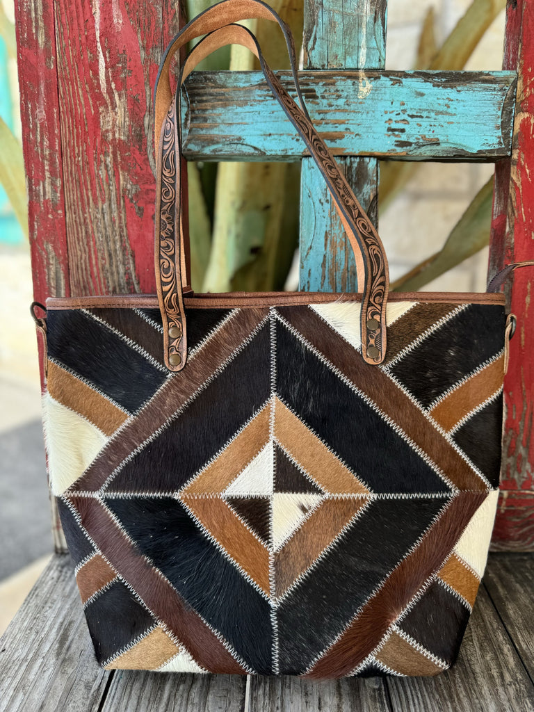  Ladies American Darling cowhide patchwork tote bag in black, brown, tan, and white, with tooled leather straps and detachable crossbody strap – ADBG533C. Available at Blair's Western Wear, Marble Falls, TX.
