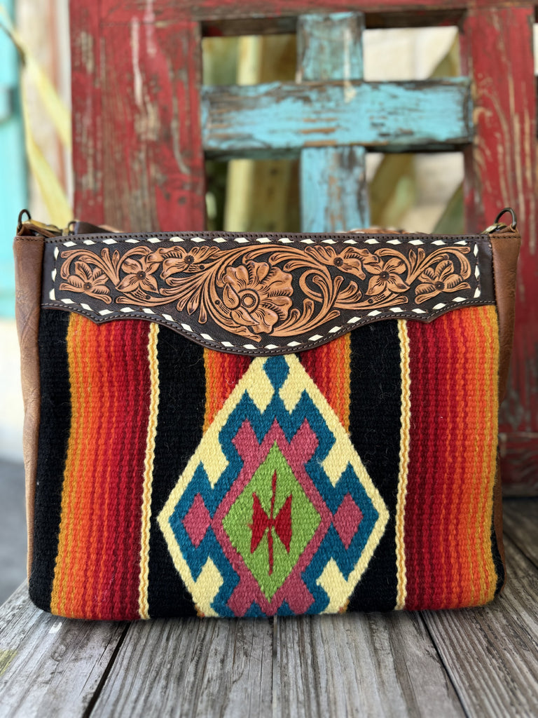  Ladies American Darling Western Tote Purse in brown leather & multicolor saddle‑blanket body, hand‑tooled leather trim with adjustable crossbody strap – ADBGA180. Available at Blair's Western Wear, Marble Falls, TX.