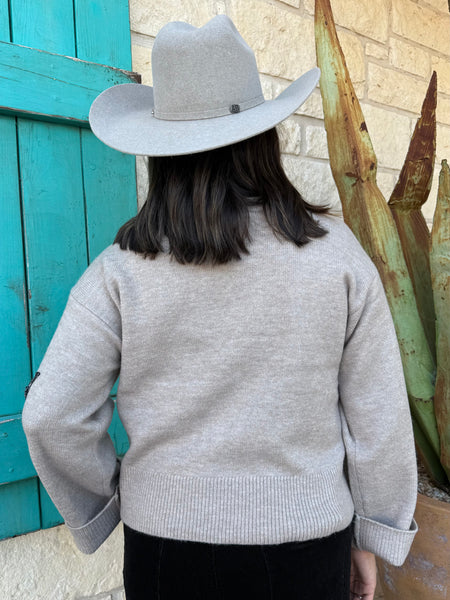 Cozy meets chic in this Ariat knit sweater, featuring a warm tan base with striking black floral embellishments along the shoulder and sleeve. Its mock-neck design, ribbed details, and relaxed fit make it the perfect blend of comfort and style for any season. Available at BLAIR'S Western Wear located in Marble Falls TX.
