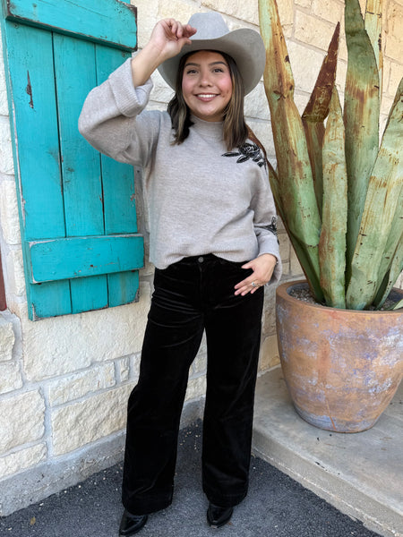 Cozy meets chic in this Ariat knit sweater, featuring a warm tan base with striking black floral embellishments along the shoulder and sleeve. Its mock-neck design, ribbed details, and relaxed fit make it the perfect blend of comfort and style for any season. Available at BLAIR'S Western Wear located in Marble Falls TX.
