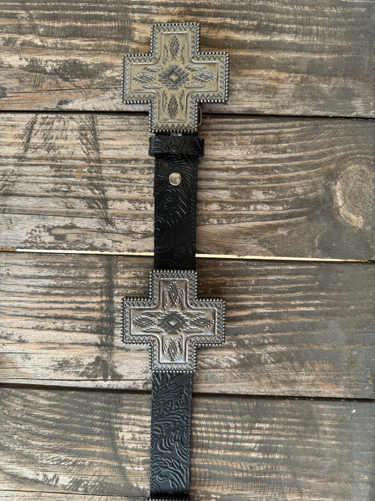 Black genuine leather belt with deep floral tooling and oversized cross-shaped silver conchos featuring Aztec-inspired engraving, a beaded rope border, and a diamond center stone. A bold western statement piece for any occasion.

Available at Blair's Western Wear, Marble Falls, TX