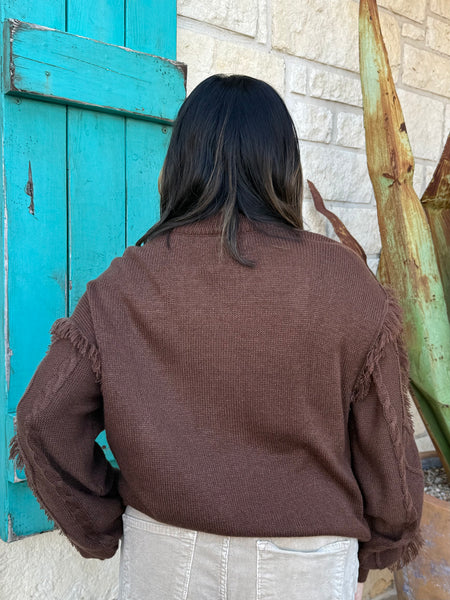 Ladies Aztec Sweater crafted in a warm brown knit, featuring a bold Aztec design in mint and natural tones along with soft fringe detailing down the sleeves. Its relaxed fit and textured finish make it perfect for pairing with your favorite denim or cords, all while keeping you stylish and comfortable through the cooler seasons. Available at BLAIR'S Western Wear located in Marble Falls TX.

