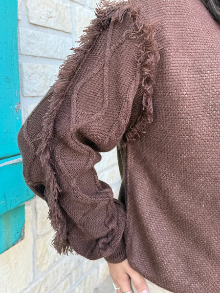 Ladies Aztec Sweater crafted in a warm brown knit, featuring a bold Aztec design in mint and natural tones along with soft fringe detailing down the sleeves. Its relaxed fit and textured finish make it perfect for pairing with your favorite denim or cords, all while keeping you stylish and comfortable through the cooler seasons. Available at BLAIR'S Western Wear located in Marble Falls TX.
