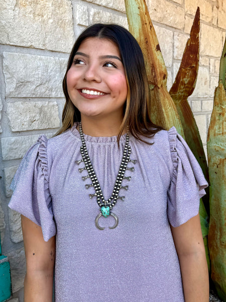 This shimmery lavender Ivy Jane dress brings easy feminine charm with its flutter sleeves, soft knit fabric, and flouncy ruffle hem. Perfect for everyday wear or a dressed-up look, it’s a comfortable standout piece for any wardrobe. Available at BLAIR’S Western Wear located in Marble Falls, TX.
