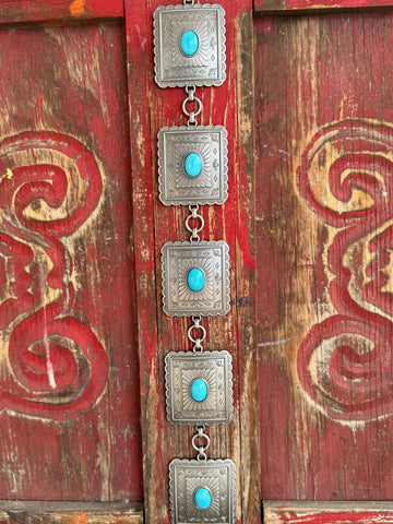 Ladies M & F Western concho belt in silver with turquoise stones, featuring scalloped square conchos and adjustable chain links for a perfect fit – A1567433. Available at Blair’s Western Wear, Marble Falls, TX.