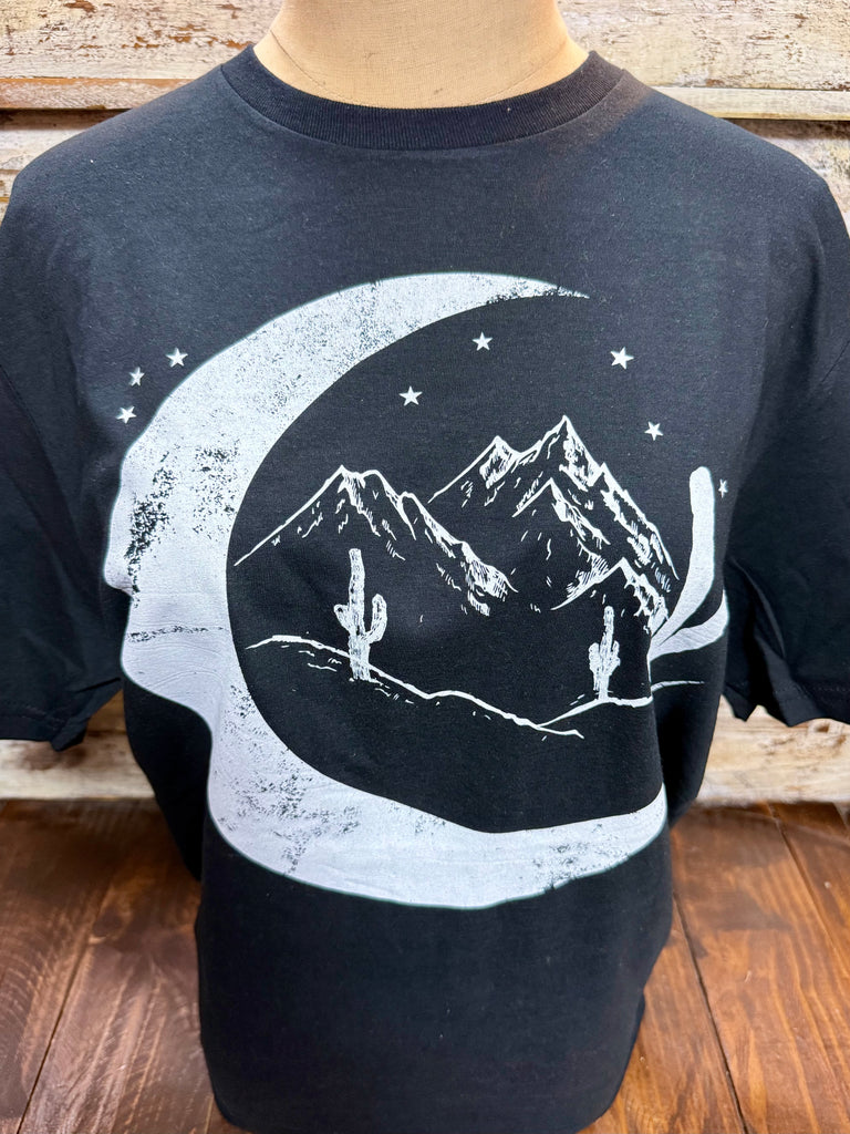 Ladies Marfa Moon short sleeve graphic tee in black, soft breathable cotton blend for all-day comfort, with a bold crescent moon desert landscape graphic featuring mountains and cacti – MARFA MOON. Available at Blair's Western Wear, Marble Falls, TX.