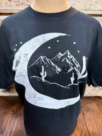 Ladies Marfa Moon short sleeve graphic tee in black, soft breathable cotton blend for all-day comfort, with a bold crescent moon desert landscape graphic featuring mountains and cacti – MARFA MOON. Available at Blair's Western Wear, Marble Falls, TX.
