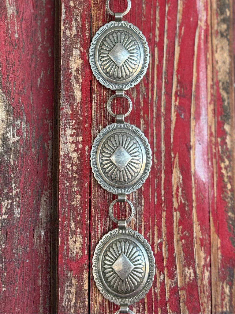 Turn any outfit into a statement with this eye-catching concho belt. Oval silver conchos detailed with Aztec-inspired engraving bring bold Western character to everything from your favorite jeans to a flowy sundress — effortlessly styled, endlessly versatile.