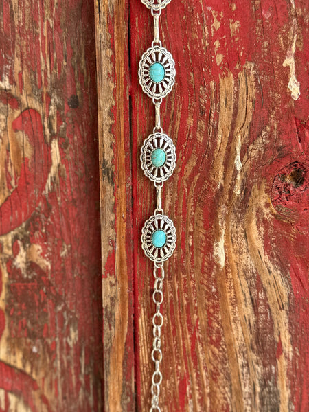 Petite oval silver conchos with scalloped sunburst-stamped edges and a vibrant turquoise stone center, linked by a delicate silver chain — this belt brings understated Southwestern charm to any look. Dainty enough for everyday wear, distinctive enough to turn heads at any western occasion. Available at Blair's Western Wear located in Marble Falls TX 

