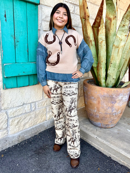 These Lucky & Blessed Western Print Trousers bring vintage cowboy vibes to any outfit. Made with a soft, lightweight fabric and a comfortable mid-rise fit, they feature an all-over brown rodeo scene print on a cream background. Finished with a flattering bootcut leg, these trousers pair perfectly with your favorite denim tops, graphic tees, or boots for an effortless western look. Available at BLAIR'S Western Wear located in Marble Falls TX.

