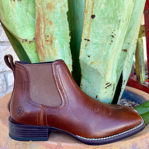 Men’s Ariat Booker Ultra brown slip-on boot in full-grain leather, wide square toe for added comfort, with elastic twin-gore panels for easy on/off – 10040289. Available at Blair's Western Wear, Marble Falls, TX.