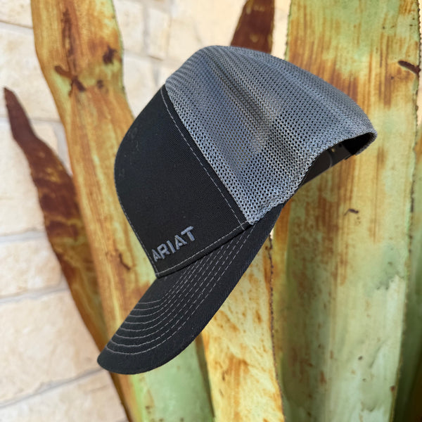 A black and gray trucker-style cap with the brand name ARIAT embroidered on the side,