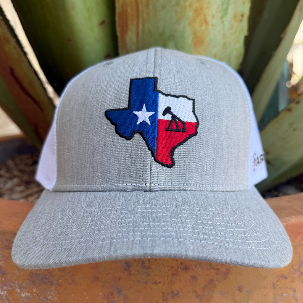 A light gray trucker hat with a Texas flag design on the front panel and an oil pump 